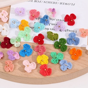 Detail von farbenfrohen handgestrickten Häkelblumen mit Metallschlaufen für DIY-Projekte