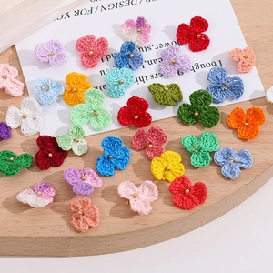 Nahaufnahme bunter gehäkelter Blumenanhänger für DIY-Schmuck und Haar-Accessoires