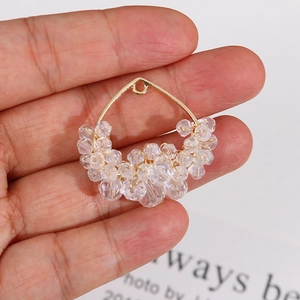 Detail of gold handmade wire-wrapped teardrop pendant with clear faceted crystal beads