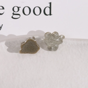 Macro shot of semi-transparent smoky gray resin flower charms for DIY jewelry making