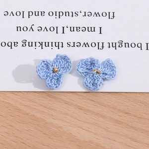 Detailaufnahme blauer Häkelblumen-Anhänger mit Goldperlen für DIY-Schmuck und Haarspangen