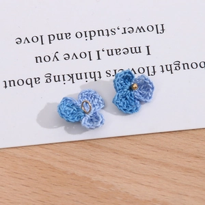 Nahaufnahme der handgefertigten hellblauen gestrickten dreiblättrigen DIY Blumenanhänger