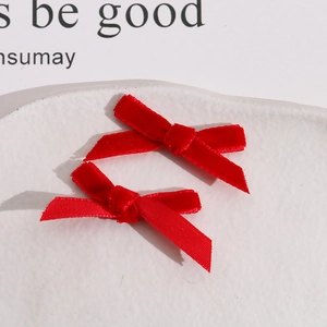 Detail of red velvet and satin ribbon bows for DIY hair accessories on white tray