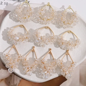 Macro detail of geometric handmade beaded charms with iridescent crystal beads on gold frames