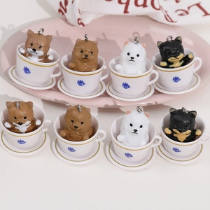 Set of eight miniature resin puppy charms in white teacups with blue logo details