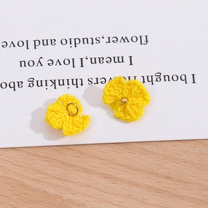 Makro-Detail gelber Häkelblumen-Anhänger mit Metallperlen und kleinen Verbindungsringen