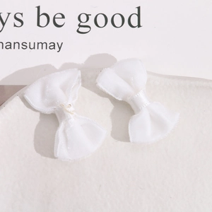 Close-up of white plush velvet bow accessories with soft texture for DIY hair clips