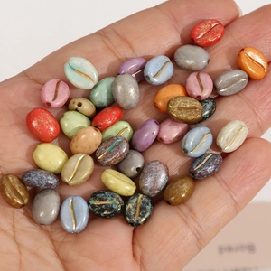 Kleurrijke koffieboon acryl kralen met gouden lijnen voor DIY sieraden in een hand