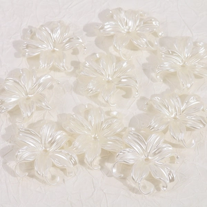 Detailed view of pearl white flower beads with central hole for DIY jewelry making