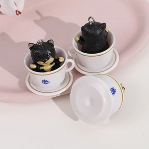 Detail of cute Shiba Inu resin figurine inside a white teacup with a golden hook