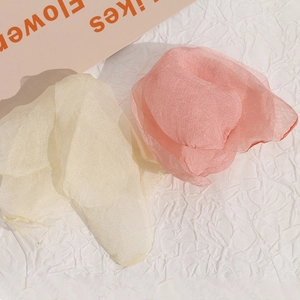 Dettaglio ravvicinato di accessori per capelli a fiori in rete beige e rosa cipria