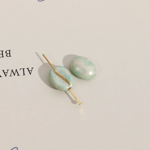 Macrodetail van ovale acryl koffieboon kralen met gouden lijnen voor DIY-sieraden