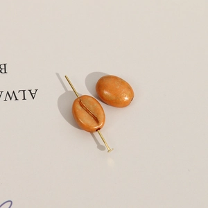 Macro-opname van acryl koffieboon kralen met gouden textuur voor DIY sieraden maken