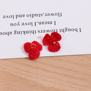 Detail von roten gehäkelten Blütenanhängern mit goldenem Metallring für DIY-Schmuck