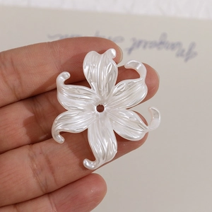 Macro view of pearlescent white lily flower bead with central hole for DIY jewelry making
