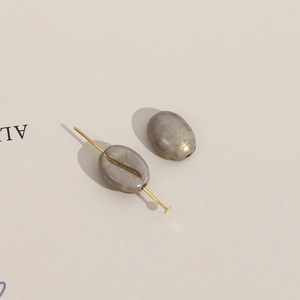 Detailopname van koffieboonkralen met gouden spetters voor DIY-sieraden maken