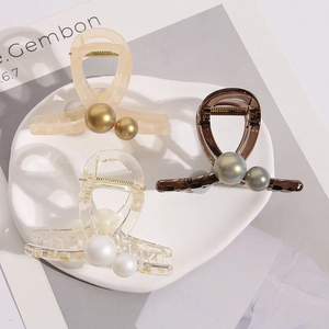 Detalle de pinzas para el cabello de resina con perlas en beige, marrón y estilo transparente