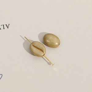 Macro-detail van koffieboon acrylkralen met gouden lijnen voor DIY sieraden maken