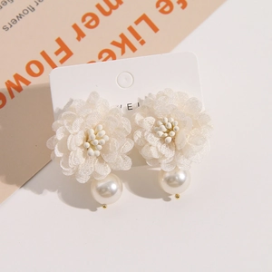Detail of cream tulle flower earrings with elegant white pearls on display card