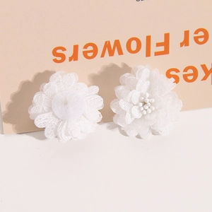 Detailed view of white multi-layer mesh flower accessories with delicate beaded centers