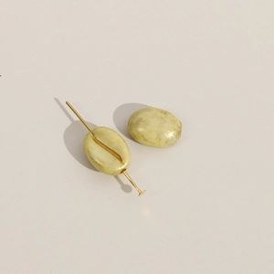 Detail van koffieboon acrylkralen met steentextuur en gouden pinnen voor DIY sieraden