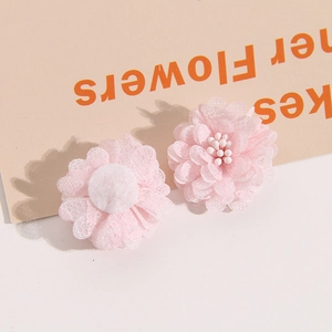 Detail of pink mesh flower accessories with layered fabric petals and soft white stamens