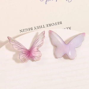Close-up of pink glitter butterfly and purple resin charms for DIY jewelry making