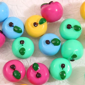 Dettaglio di mini perline colorate a mela con fori di filettatura per gioielli fai-da-te