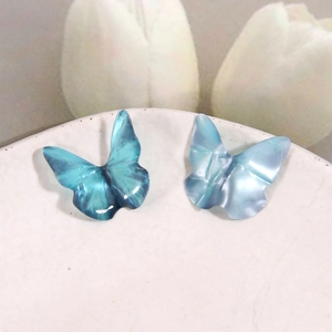 Detailed macro view of 3D resin butterfly charms in gradient blue for jewelry DIY