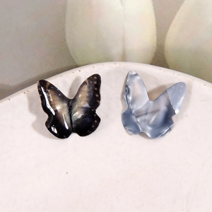 Macro view of 3D resin butterfly charms for DIY jewelry making in various color gradients