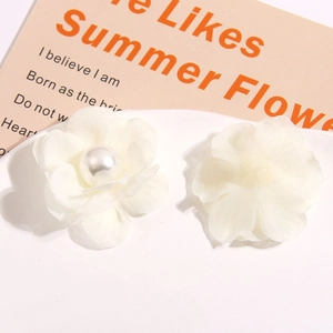 Macro detail of white chiffon camellia fabric flowers with pearl centers for DIY crafts
