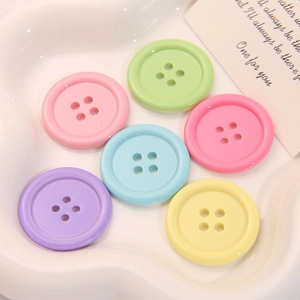 Bottoni rotondi in resina macaron a 4 fori esposti su un vassoio bianco strutturato