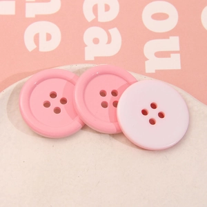 Dettaglio dei bottoni rotondi rosa a quattro fori in resina per cucito e artigianato