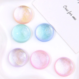 Macro shot of glittery round resin cabochons in iridescent pastel colors for DIY crafts