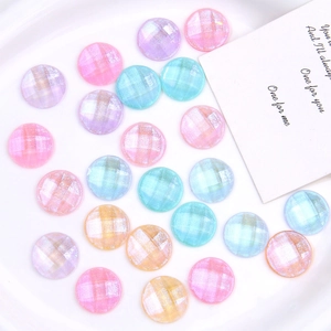 Macro detail of colorful glitter resin round charms with faceted grid pattern for DIY crafts