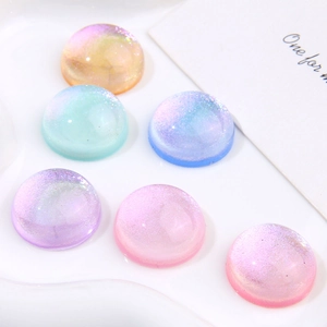 Macro shot of colorful glitter resin cabochons with gradient starry sky texture for DIY