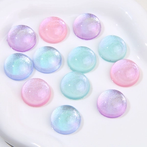 Close-up of sparkling pastel resin cabochons in a white ceramic tray for DIY crafts