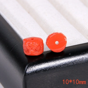 Vista macro di perle leone rosso cinabro 10x10mm con intricate incisioni tradizionali