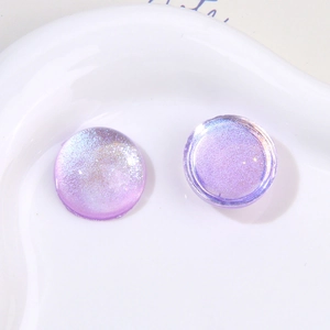 Macro view of purple glitter resin charms with iridescent finish and round design