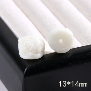 Dettaglio macro di perline a fiori intagliati bianchi da 13x14mm per creazione gioielli