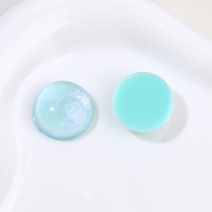 Detail of round resin charms with blue aurora pearlescent and mint green glossy finishes