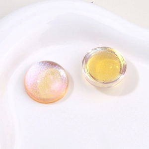 Macro detail of round starry resin patches with iridescent glitter for DIY jewelry making