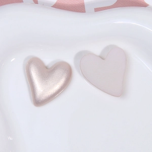 Detail von herzförmigen DIY-Accessoires aus Kunstperlen in Perlrosa und mattem Weiß-Finish