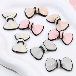 Close-up of elegant acetate bow charms in assorted colors for DIY jewelry and crafts