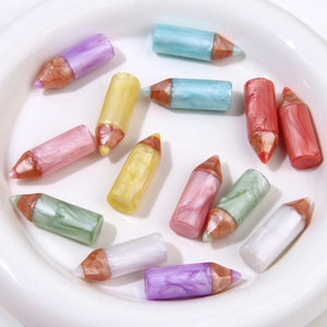 Macro shot of colorful resin pencil charms with pearlescent marble texture in a dish