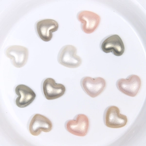 Mélange de breloques en acrylique nacré en forme de cœur dans une coupelle blanche