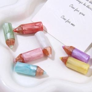 Macro shot of colorful resin pencil charms with pearlescent finish for DIY crafting