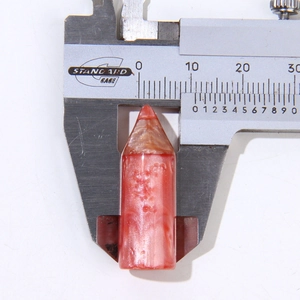 Macro detail of pink resin pencil tip charm measured with calipers for DIY accessories