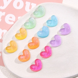 Dettaglio di ciondoli a cuore in resina colorata glitterata su vassoio bianco