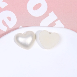 Vue macro de breloques en cœur nacrées et mates pour bijoux DIY et accessoires